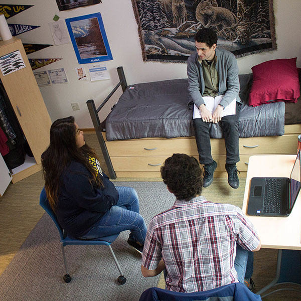 Three students sitting in a housing unit